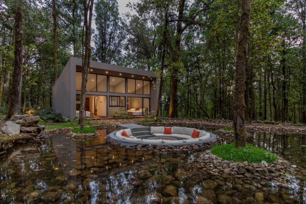Luxury house in Rancho San Simon, Valle de Bravo with outdoor seating area around pond within the forest